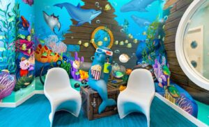 3d dolphin character with popcorn, drink, and 3d glasses in underwater themed kids theater