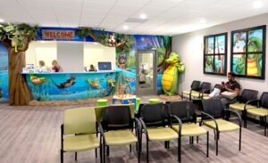 A dental office waiting area with calming sunset bayou murals and themed decor