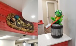 A sculpted wooden welcome sign with hay & duck accents and a custom frog mascot for a dental office reception