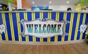 Carnival themed reception desk with 3d welcome sign and tooth characters