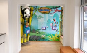 Kid's playroom with wall mural of an Asian mountain range, game tablets, and bamboo "kids corner" signage