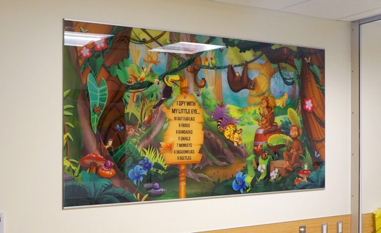 Large I spy graphic with a jungle theme hanging on the wall in a clinic waiting room