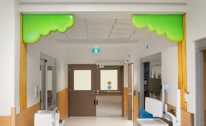 Tree mural with 3D sculpted canopy of leaves in a hospital hallway