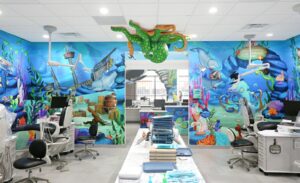 An open bay entrance with a custom wall mural depicting vibrant ocean animals and a sunken pirate ship