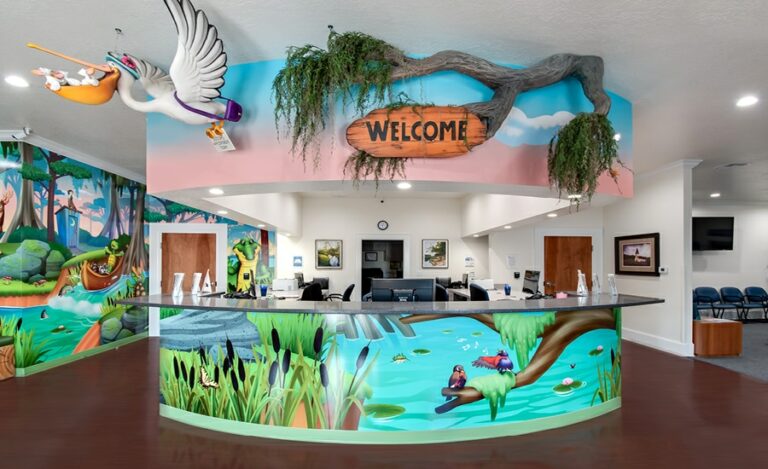 check in desk with murals, a sculpted welcome sign, and pelican sculpture