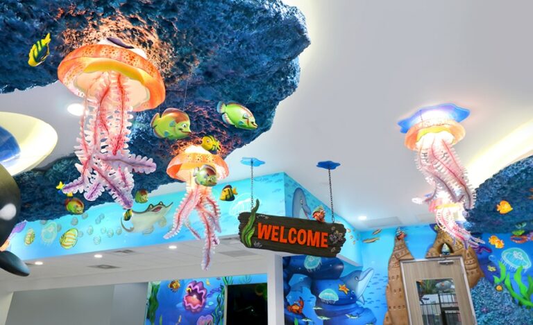 Colorful transparent jellyfish light fixtures next to fish above a clinic reception desk