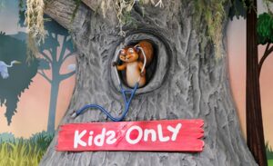 Cute squirrel character with stethoscope above kids only sign