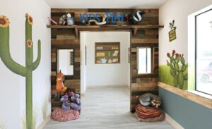 Desert themed entrance to kids play area with animal sculptures