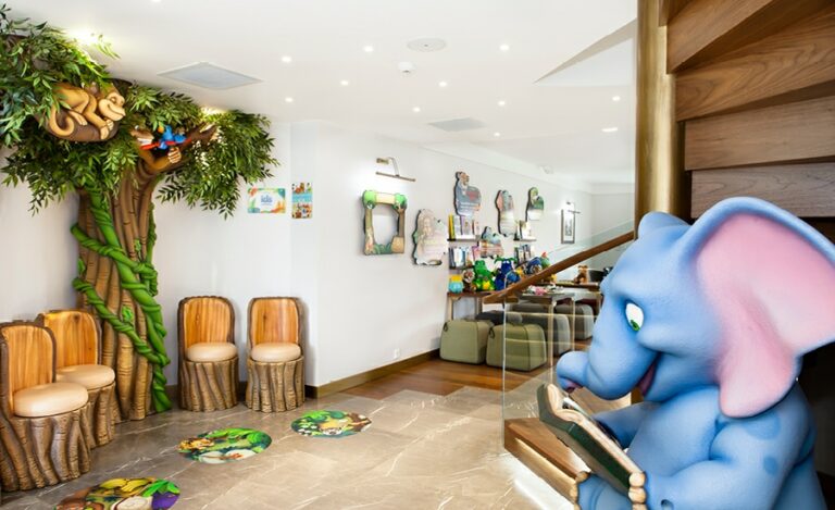 jungle themed waiting area with sculpted tree and chairs and elephant character