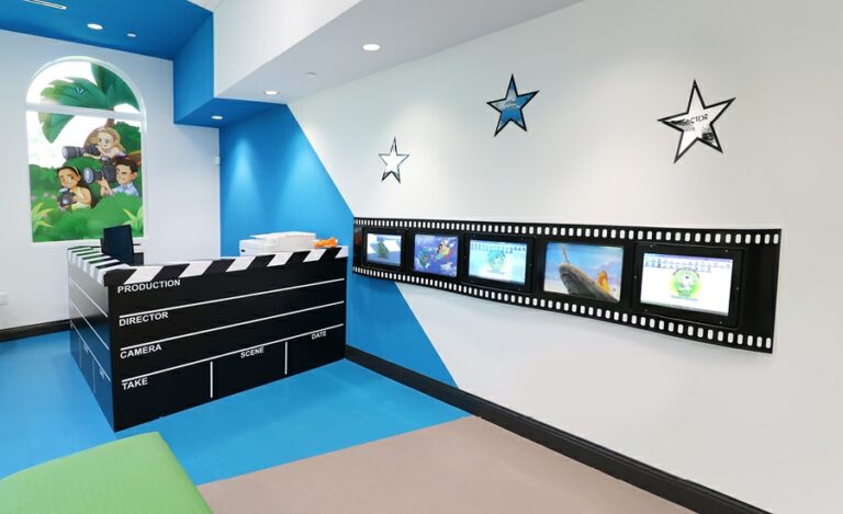 movie clapperboard themed desk and film strip gaming sculpture in kids dental office