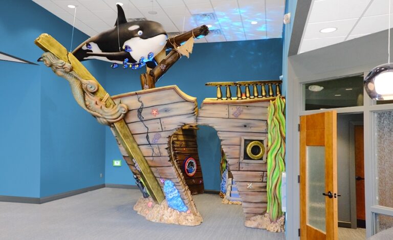 sunken ship play area with orca sculpture in medical waiting room