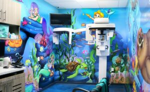 Treatment room with exciting and colorful underwater murals filled with bright underwater life and scenery
