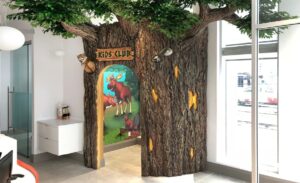 tree themed kids corner with murals in pediatric dental reception area