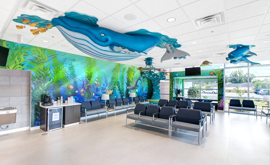 underwater themed waiting room with custom murals, whale sculpture and fish