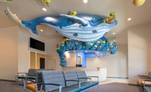 whale sculpture and underwater characters in front of themed reception desk