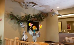 bust out sculpted tree branch with hanging animals and ducks flying overhead in a pediatric office
