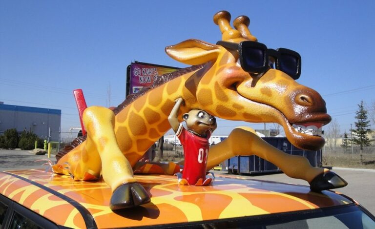 close up of a car roof mounted giraffe and meerkat sculptures for a car wrap