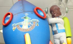 closeup of custom sculpted astronaut character next to rocket ship