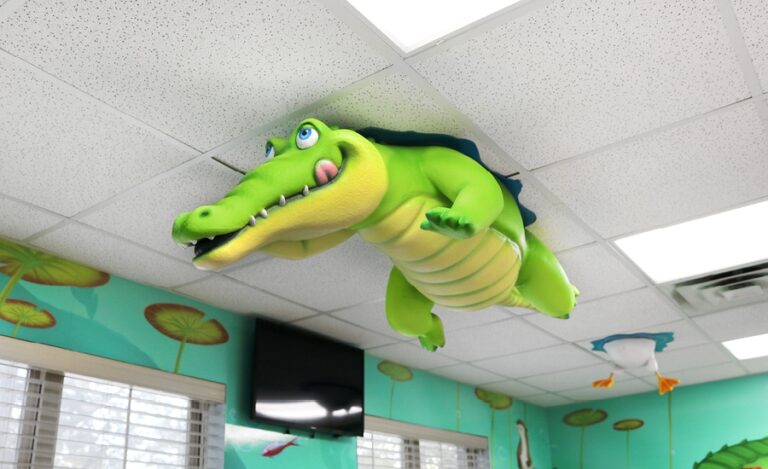 Custom ceiling sculpture of swimming alligator in pediatric treatment bay