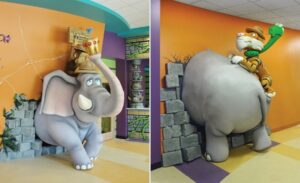 front and back view of elephant sculpture bursting through a wall