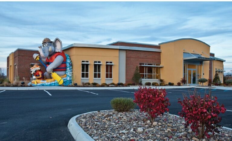 giant sculpture of elephant and tiger characters rafting outside a kids dental office