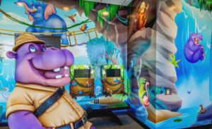 hippo adventurer photo op surrounded by bright jungle wall murals and themed kee bee gaming stations