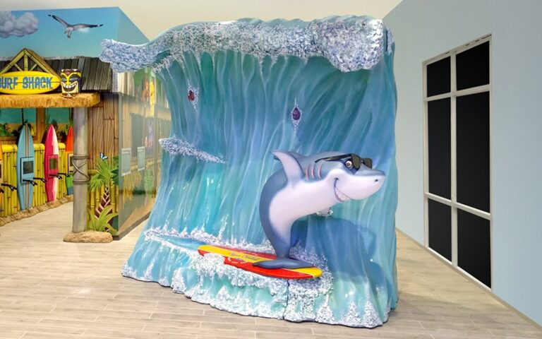 Sculpted shark riding a surfboard on a wave photo op in a dental office waiting area