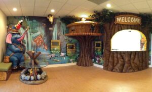 jungle themed waiting room with hut sculpture and elephant roasting marshmallows sculpture