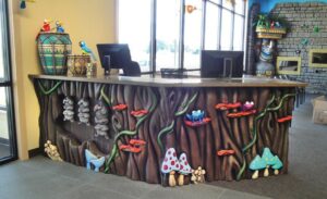 jungle forest themed reception desk with possums mushrooms and birds