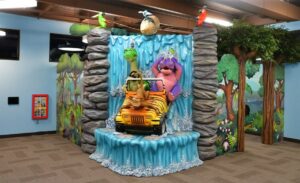 kids play area with a sculpted waterfall with characters driving a jeep