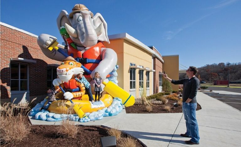 kids posing on giant elephant rafting sculpture outside a pediatric dental office