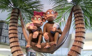 sculpted monkeys sitting in a modeled tree hammock holding popcorn and drinks in kids theater