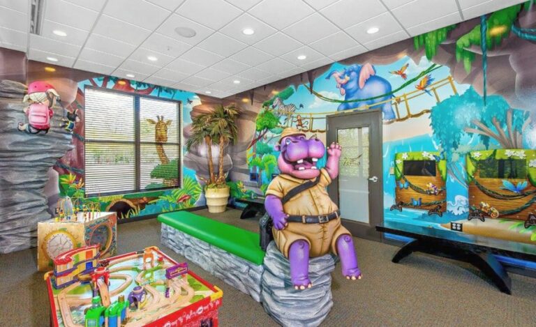 pediatric waiting room with sculpted hippo character, games, and jungle murals