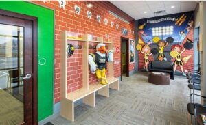 locker room themed play room with mounted game units for kids