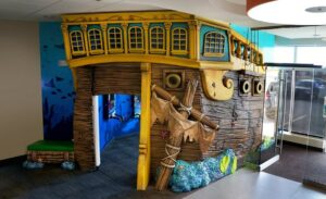 pirate ship play room with mounted game units for kids