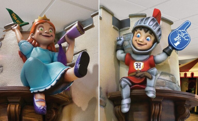 princess and knight mascots with sports paraphernalia sitting on castle turret