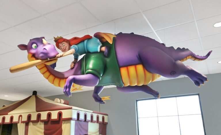 purple dragon sculpture with princess riding his back suspended from the ceiling in kids dental office