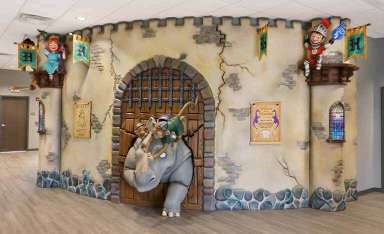 sculpted rhino charging through castle wall mural