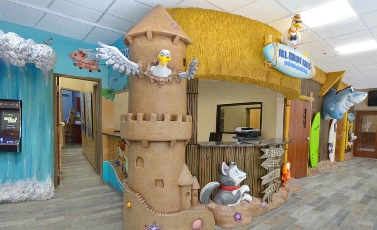 sandcastle reception desk with beach characters and murals in kids dentist office