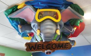 scuba diving elephant ceiling sculpture holding welcome sign for a children's dentistry