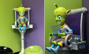 sculpted chair with a green alien reading a newspaper with built in kee bee gaming station holder