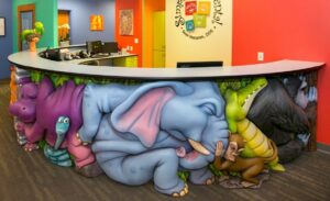 sculpted jungle animals pushing on each other for a silly jungle themed dental reception desk