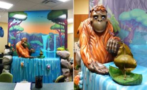 sculpted orangutan playing in a river with a jungle landscape mural for a pediatric clinic