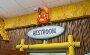 sculpted restroom sign with a cute crab character in a pediatric office