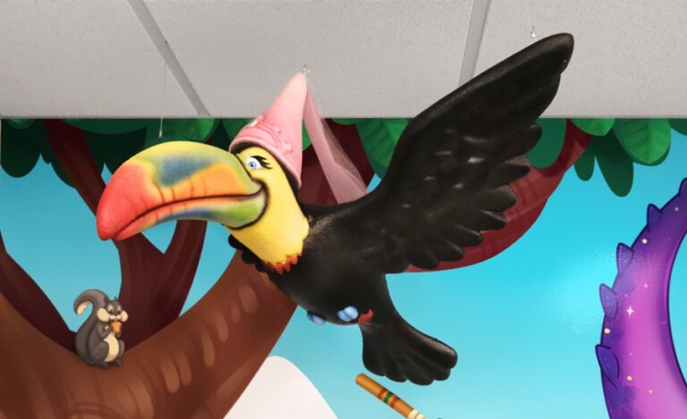 sculpted toucan with medieval princess hat suspended from treatment room ceiling