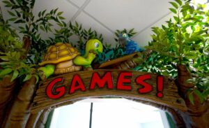 sculpted turtle and bird characters above 'games!' sign