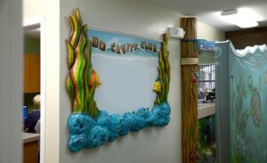 sculpted whiteboard sign with kept and fish detailing for a pediatric office