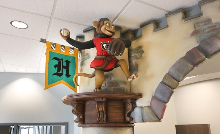sculpture of medieval monkey throwing a baseball in pediatric office
