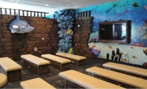 theater area lined with sunken ship inspired wall cladding and treasure chest seating
