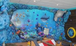undersea themed I spy mural surrounded by sculpted coral cladding